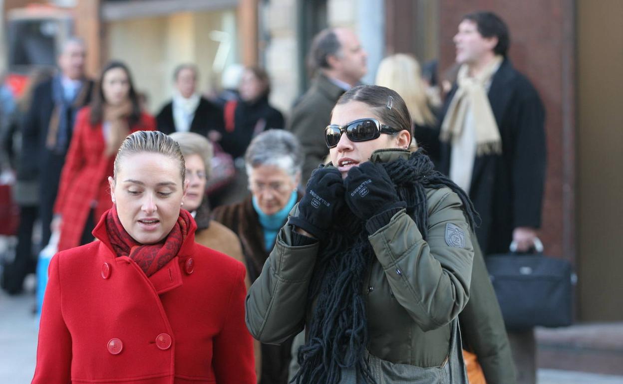 Varias personas caminan abrigadas por Bilbao.