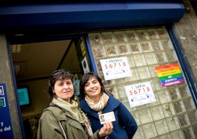 Imagen secundaria 1 - Las colas son la estampa habitual en este despacho de lotería. Ainhoa Asenjo muestra el boleto que le ha comprado a su madre. Abajo, Josean, uno de los loteros, coloca un cartelote del sorteo del Gordo.