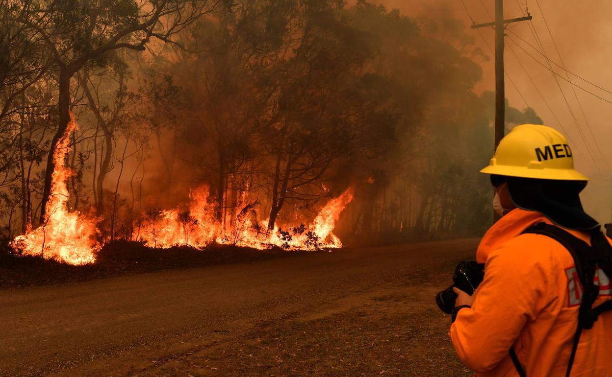 Una fotógrafa observa uno de los incendios en Bilpin, Nueva Gales del Sur, Australia.