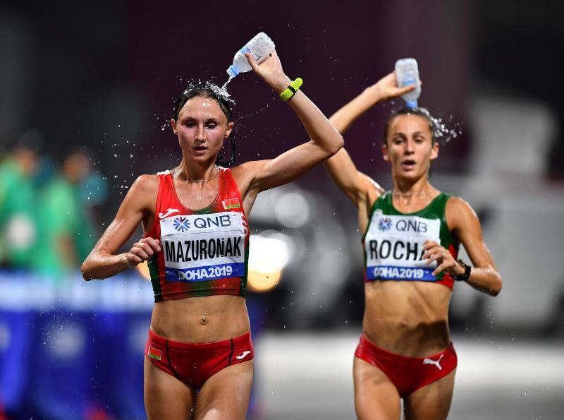 Volha Mazuronak (Bielorrusia) y Salomé Rocha (Portugal) se hidratan durante el maratón del Mundial de atletismo en Doha. 28 de septiembre de 2019.