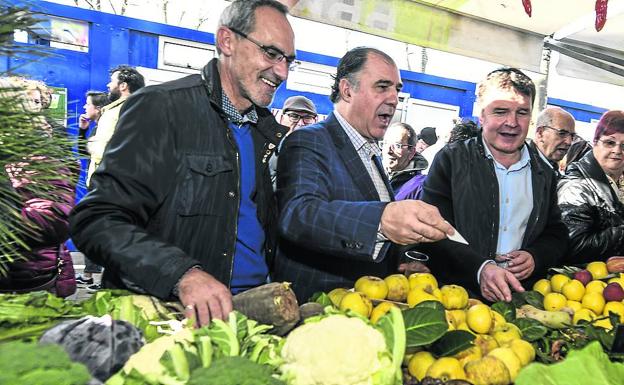 Ondarra, González e Iriondo visitan el puesto de una baserritarra en la feria.