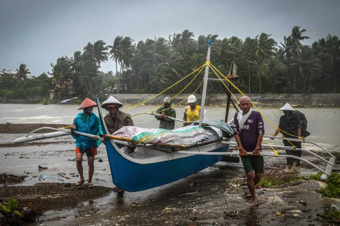Pescadores llevan un bote a tierras más altas en Baybay, Sámar, Filipinas