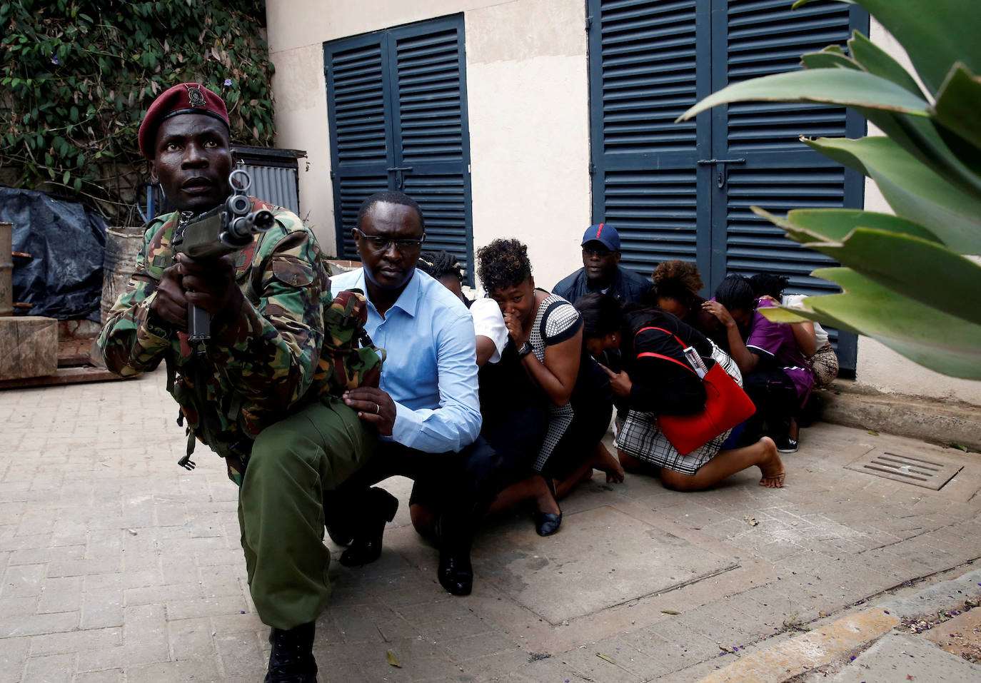 Kenia | Un miembro de las fuerzas de seguridad evacúa a las varias personas tras producirse varias explosiones en el complejo hotelero Dusit, en Nairobi, el 15 de enero de 2019. 