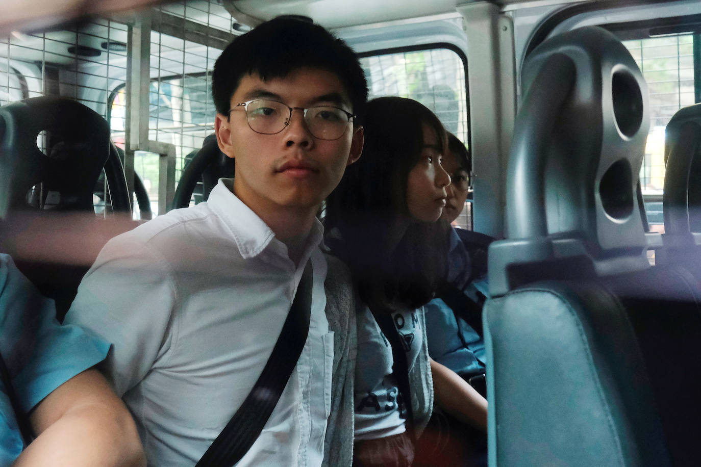 Hong Kong | Los activistas en favor de la democracia Joshua Wong y Agnes Chow llegan al Tribunal del Este en una camioneta de la policía, tras ser arrestados bajo sospecha por organizar protestas ilegales, el 30 de agosto de 2019. 