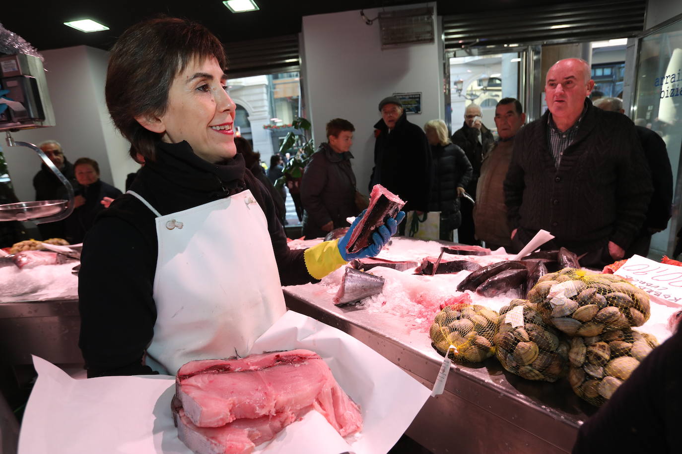 La dependienta del Arrain Bizia atiende a sus clientes que hacen cola para comprar su pescado.