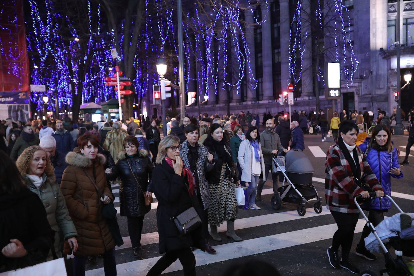 Intensa actividad en la Gran Vía, con el alumbrado navideño de fondo.