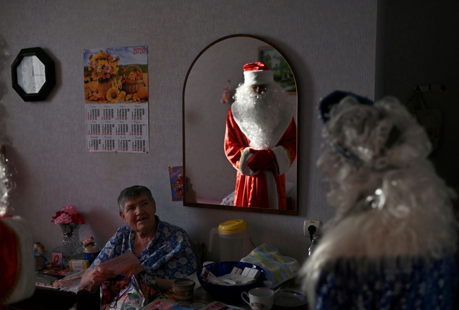 Un voluntario disfrazado de "Ded Moroz" ("Abuelo de las Nieves"), el Santa Claus eslavo, ofrece un regalo a una interna en una residencia de ancianos en Sosnovskoye, en la región de Omsk (Rusia)