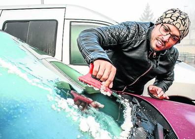 Imagen secundaria 1 - 1. Jone (izquierda) y sus amigos combaten el frío de su lonja con mantas, lonas y un radiador. 2. Jaber rasca el hielo de su coche todos los días. 3. Fernando y su nieto Mikel recojen leña para la chimenea en Campezo. 