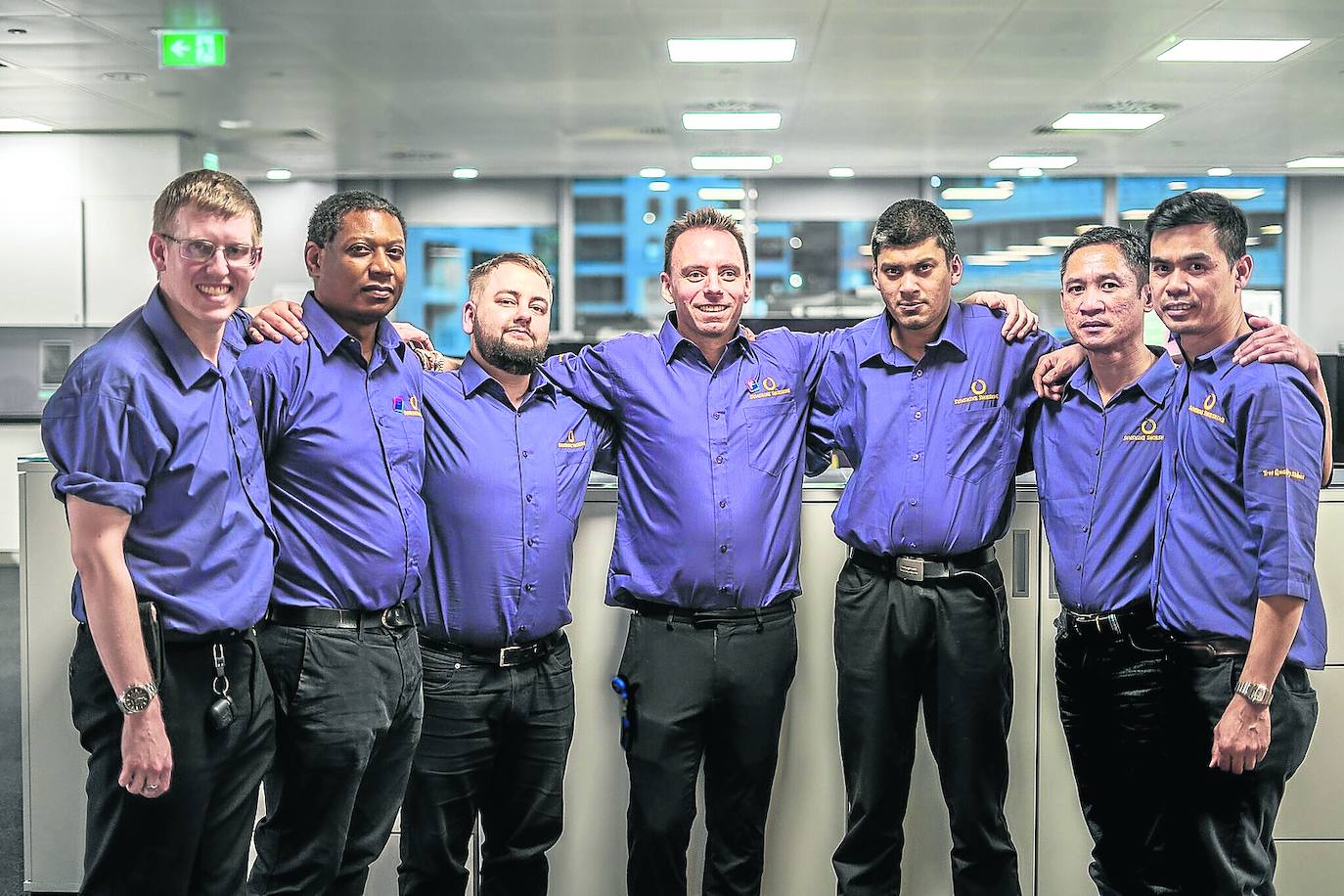 Drew Goodall, en el centro, rodeado de algunos de los trabajadores de Sunshine Shoeshine. 