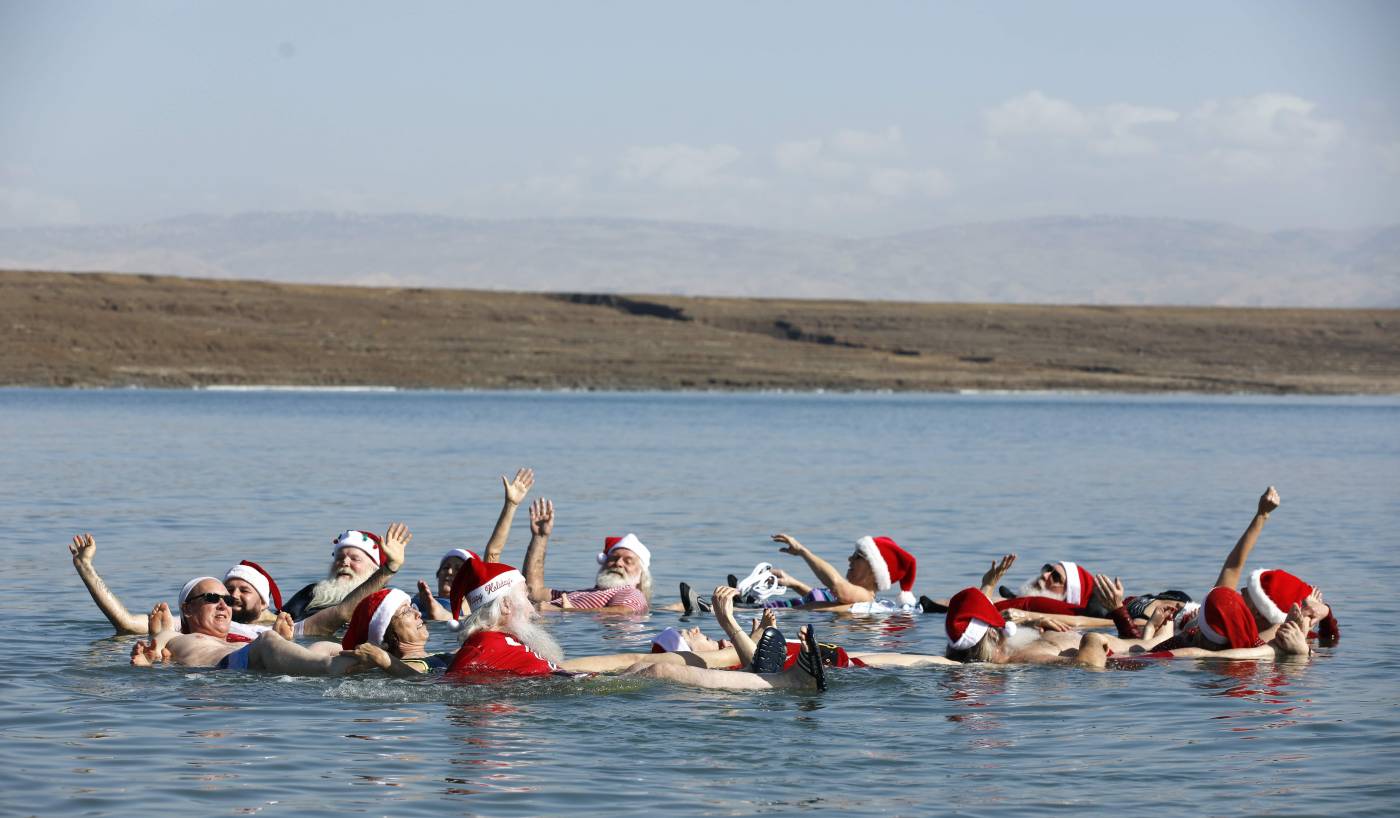 Un grupo de unas 50 personas de varios países del mundo vestidas como Santa Claus, nadan en el Mar Muerto al sur de la ciudad cisjordana de Jericó, como parte de una visita a Tierra Santa. 