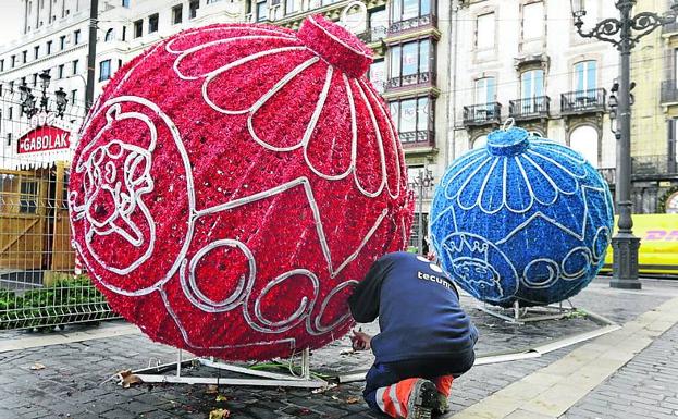 Un operario desmonta las bolas de Navidad junto al Arriaga.