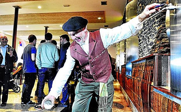 Un hombre llena su vaso de sidra en las kupelas de Kuartango. 