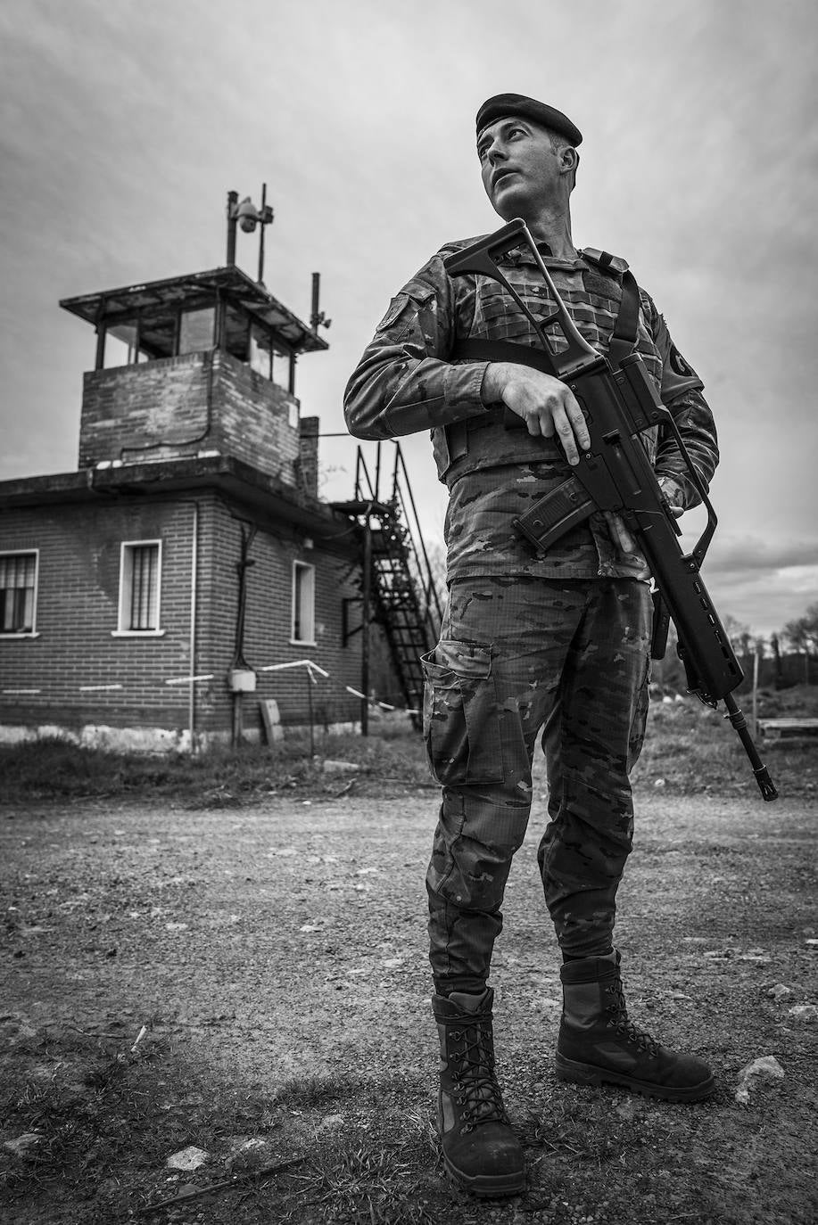 Un soldado monta guardia junto al perímetro del acuartelamiento, desde donde se accede a una zona arbolada utilizada durante la instrucción.