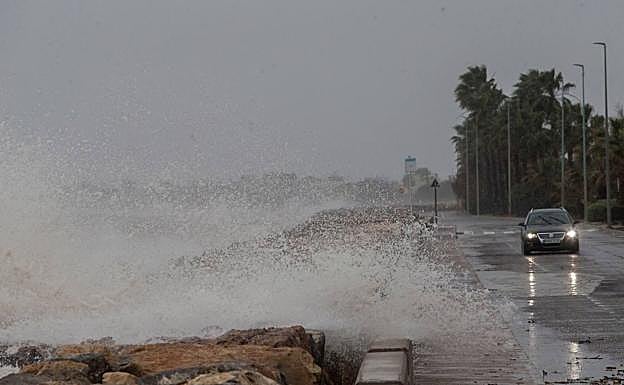 Imagen principal - El mar entra en la carretera en Burriana (Castellón) (arriba). La lluvia cayó en Valencia con intensidad (medio). El aeropuerto de Alicante cerrado durante la jornada (abajo).