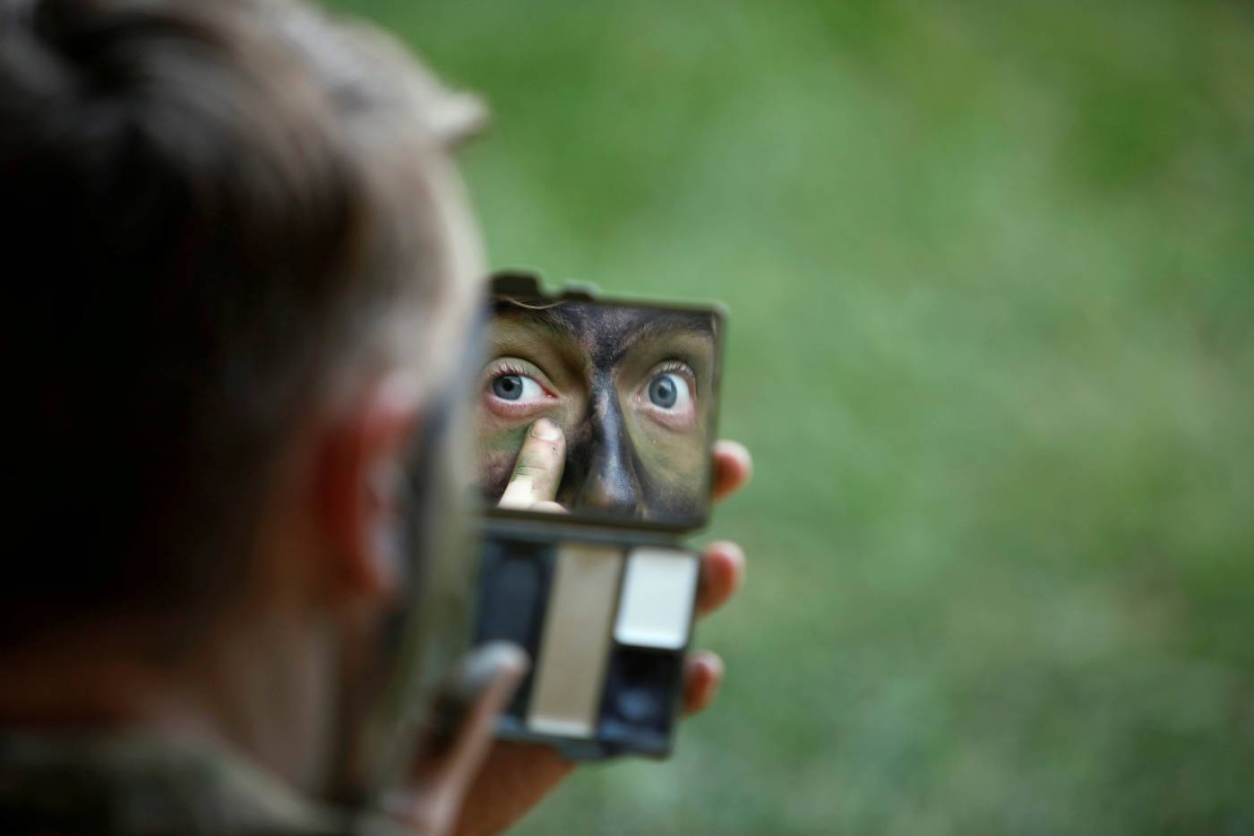 Un paracaidista de la 82 División Aerotransportada del Ejército de EE. UU. Aplica pintura de camuflaje con la ayuda de un espejo antes de un salto combinado con el 2º Batallón de las Fuerzas Especiales de Colombia en la base militar de Tolemaida, Colombia.