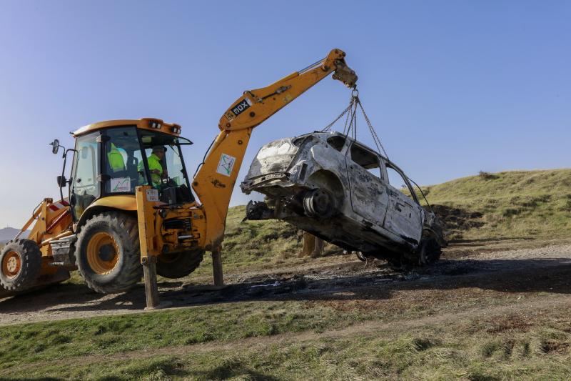 Una grúa retira el vehículo calcinado.