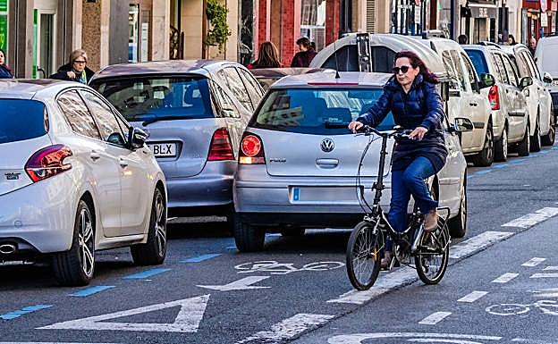 Una ciclista sortea un coche aparcado en el carril bici de la calle Gorbea.