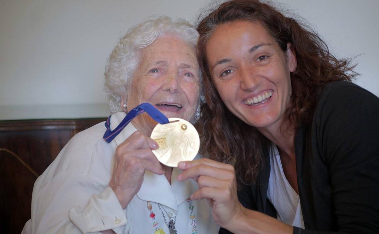 Encarna Hernández junto a Laia Palau, posando con una de las medallas que ha logrado la actual jugadora del Girona. 