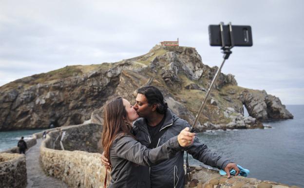 Una pareja se hace un retrato, ayer, en el camino que conduce a la ermita de San Juan de Gaztelugatxe.