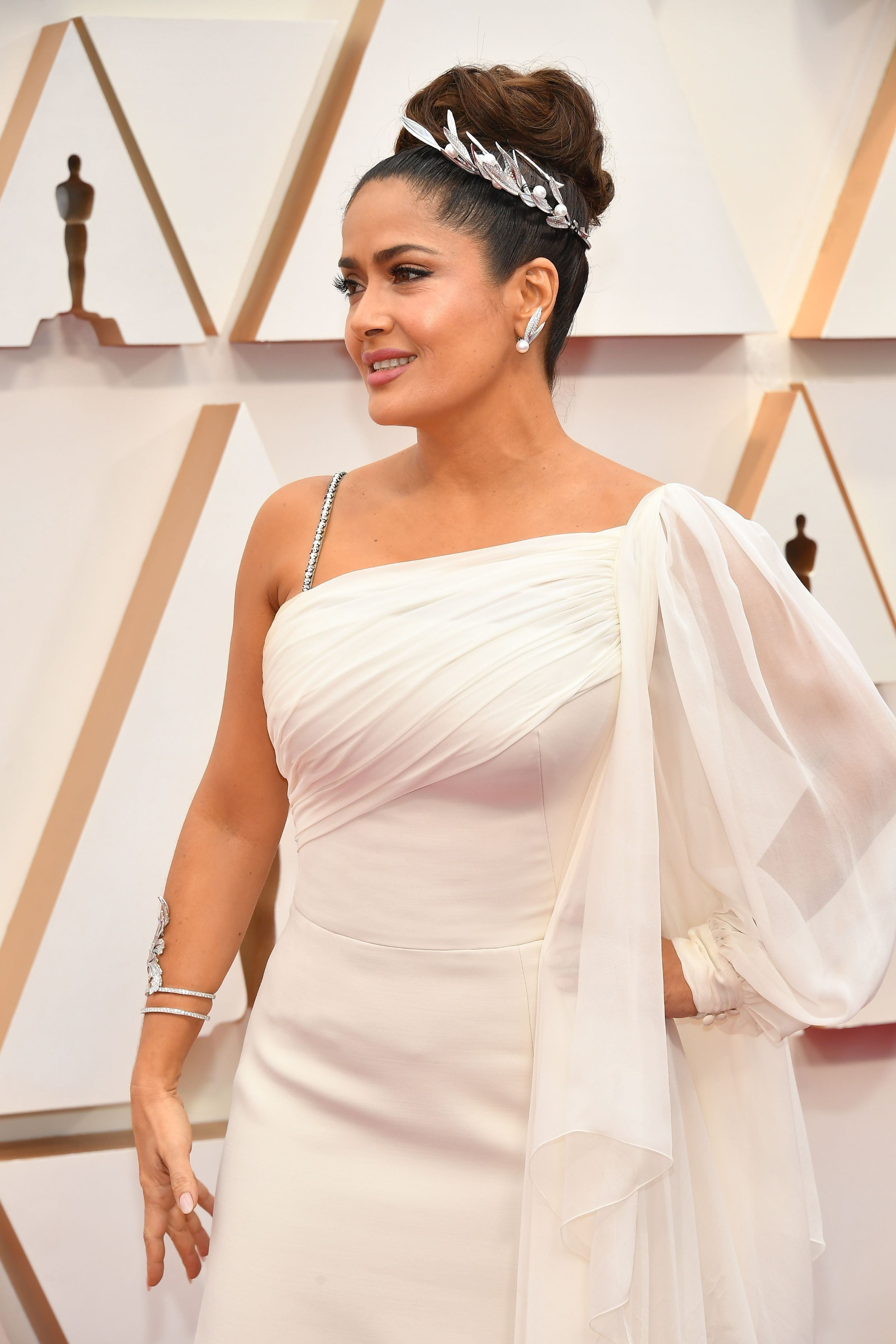 Salma Hayeck tampoco ha estado demasiado acertada con un look de inspiración griega demasiado obvio. Aplicar la tendencia helénica está bien en pequeñas dosis, pero la actriz se ha puesto hasta la tiara floral a juego de un vestido blanco, vaporoso y con escote asimétrico, firmado por Gucci.