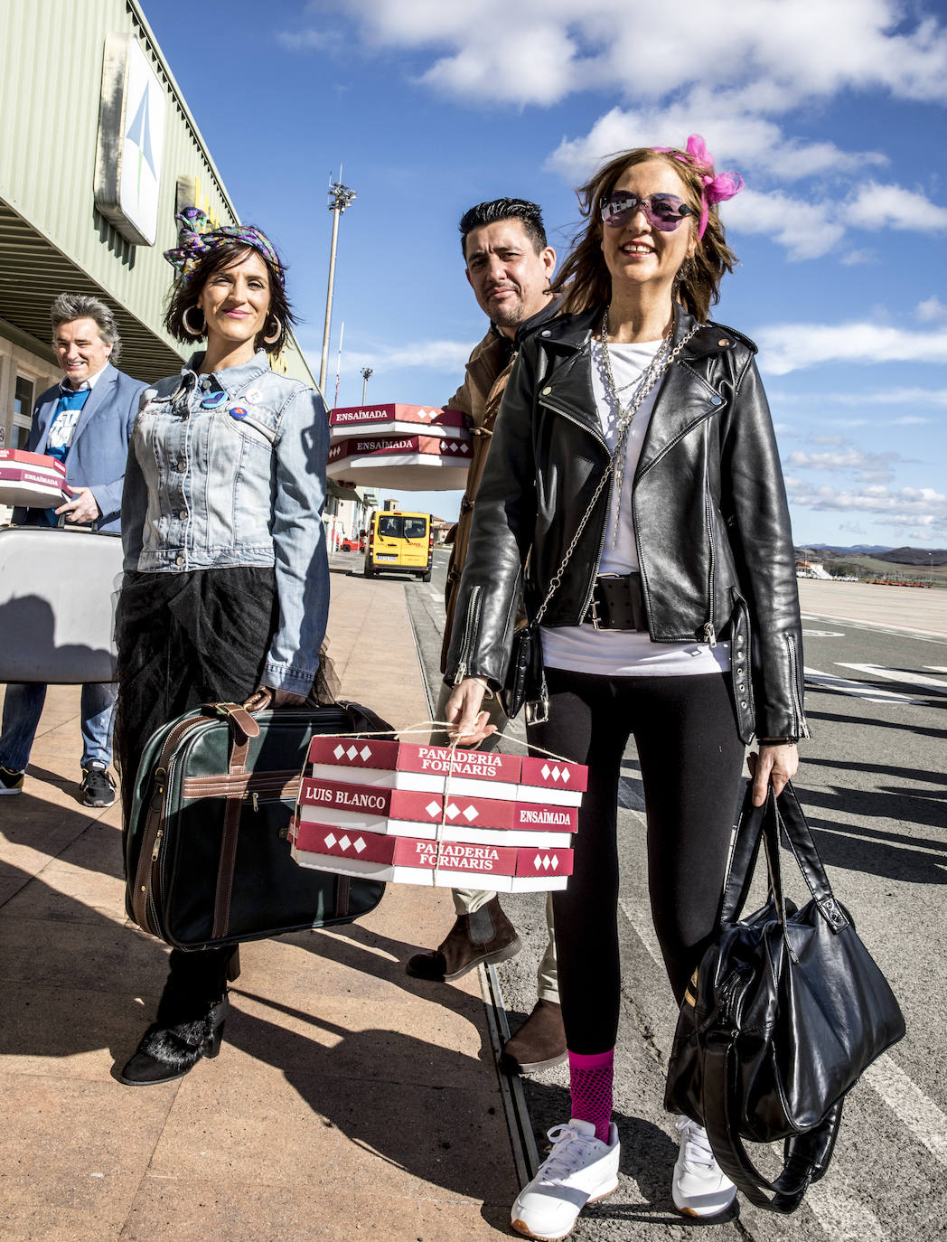 Los pasajeros se dirigen a la terminal, con sus maletas y con las típicas ensaimadas mallorquinas. 