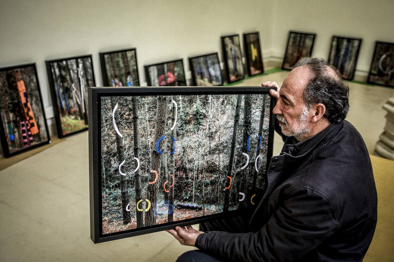 José Ibarrola, hijo de Agustín, posa con una de las obras de la muestra de fotografia del bosque de Oma, el pasado 13 de marzo en Montehermoso.