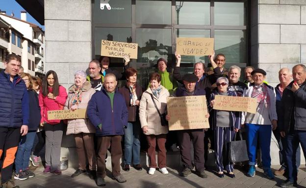 Vecinos de Urkabustaiz se concentran los lunes, el único día de apertura de la sucursal, delante de la oficina de Kutxabank en Izarra.