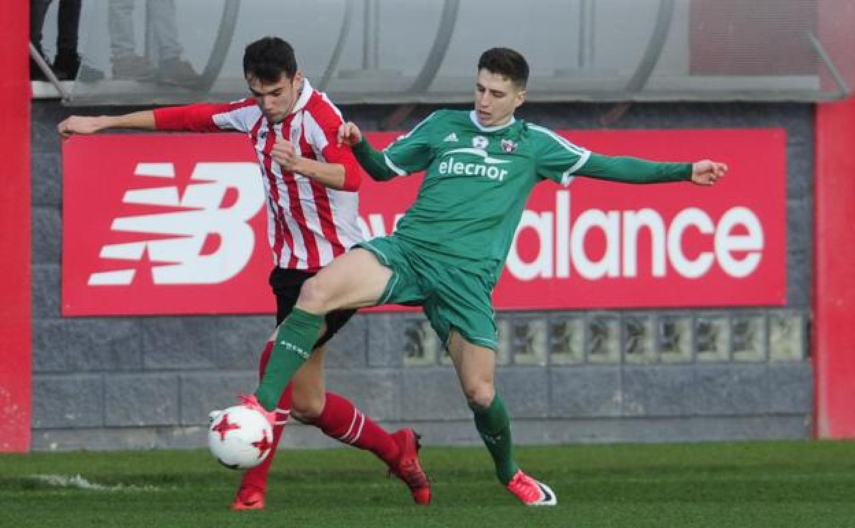 Dos jugadores luchan por un balón.