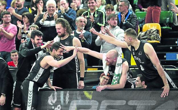 Jugadores del Bilbao Basket felicitan a Rafa Martínez ante un luminoso con publicidad de RETAbet.