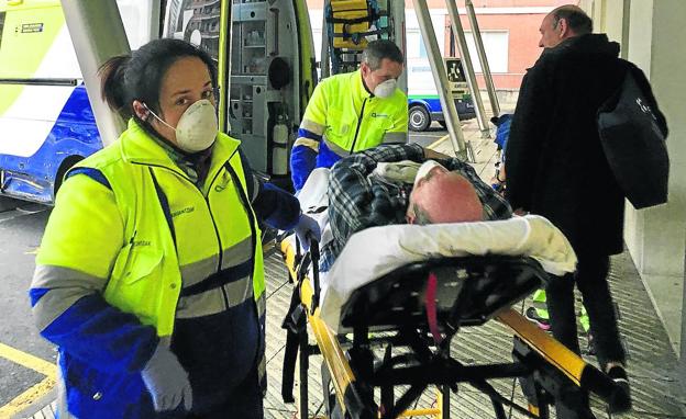 Personal de ambulancias trasladan a un paciente que nada tiene que ver con el coronavirus, cumpliendo la orden de llevar mascarilla.