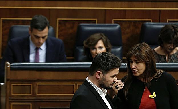 - El portavoz de ERC, Gabriel Rufián (i), conversa con la portavoz de JxCat, Laura Borrás, ante el escaño del candidato a la Presidencia del Gobierno, Pedro Sánchez.