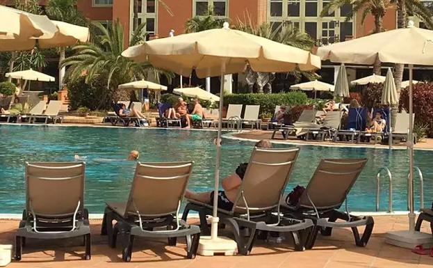 Los turistas en la piscina del hotel. 