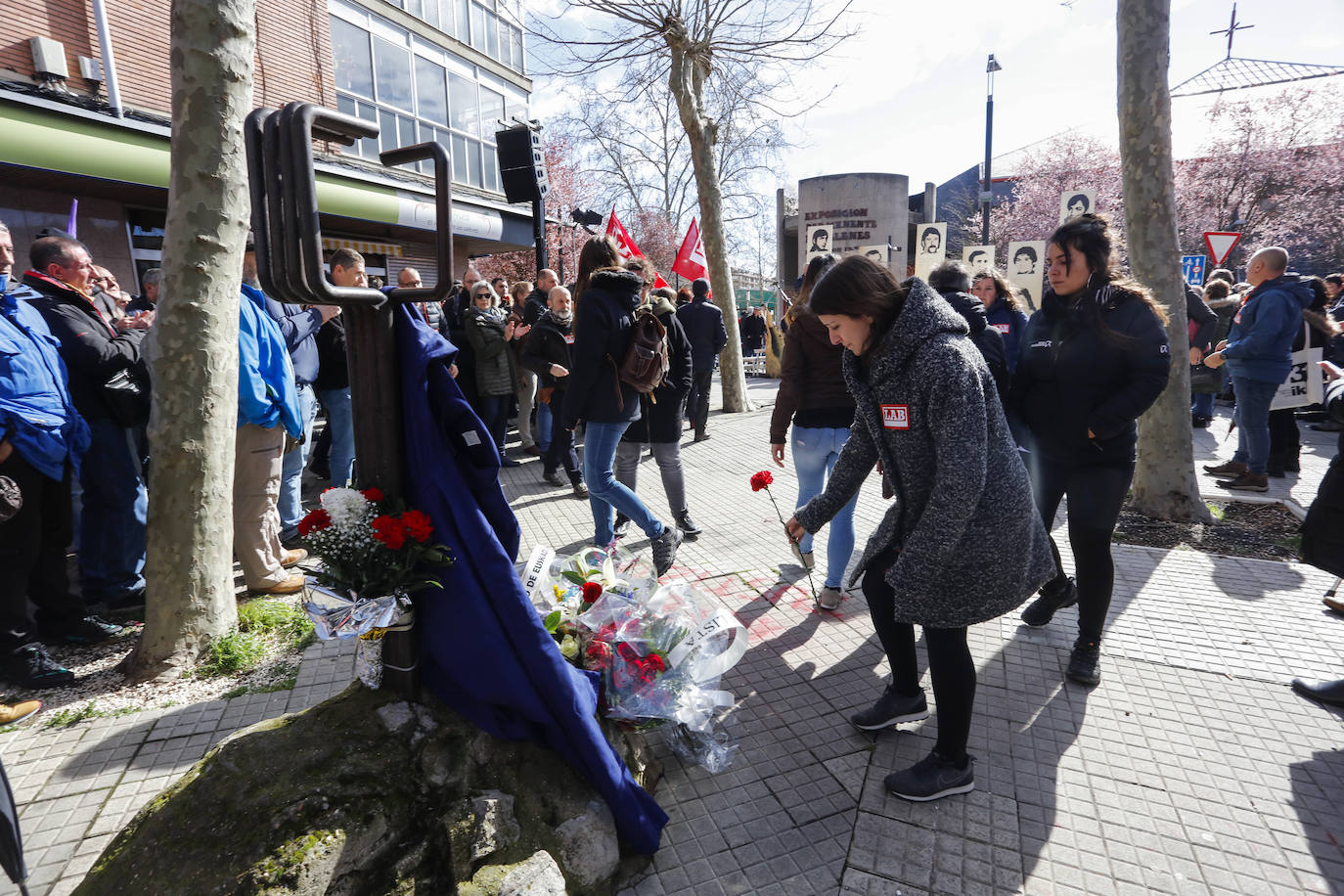 Representantes de LAB depositan claveles junto al monolito. 