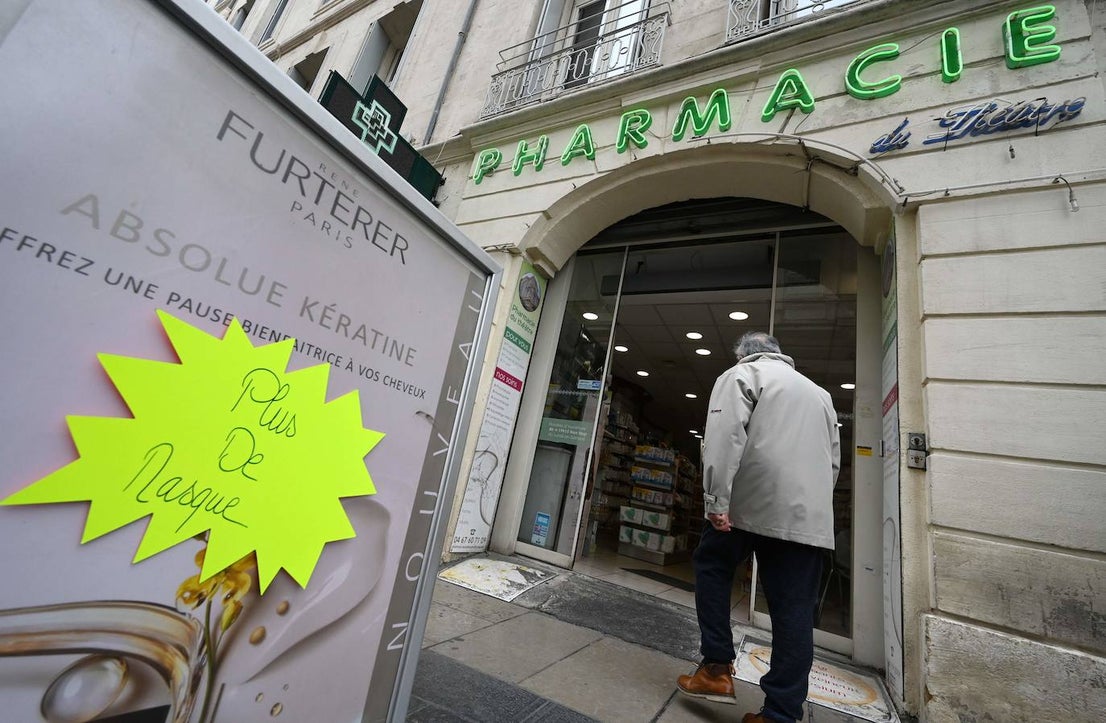 Un hombre entra a un farmacia de Montpellier en la que un cartel avisa que se han agotado las mascarillas.