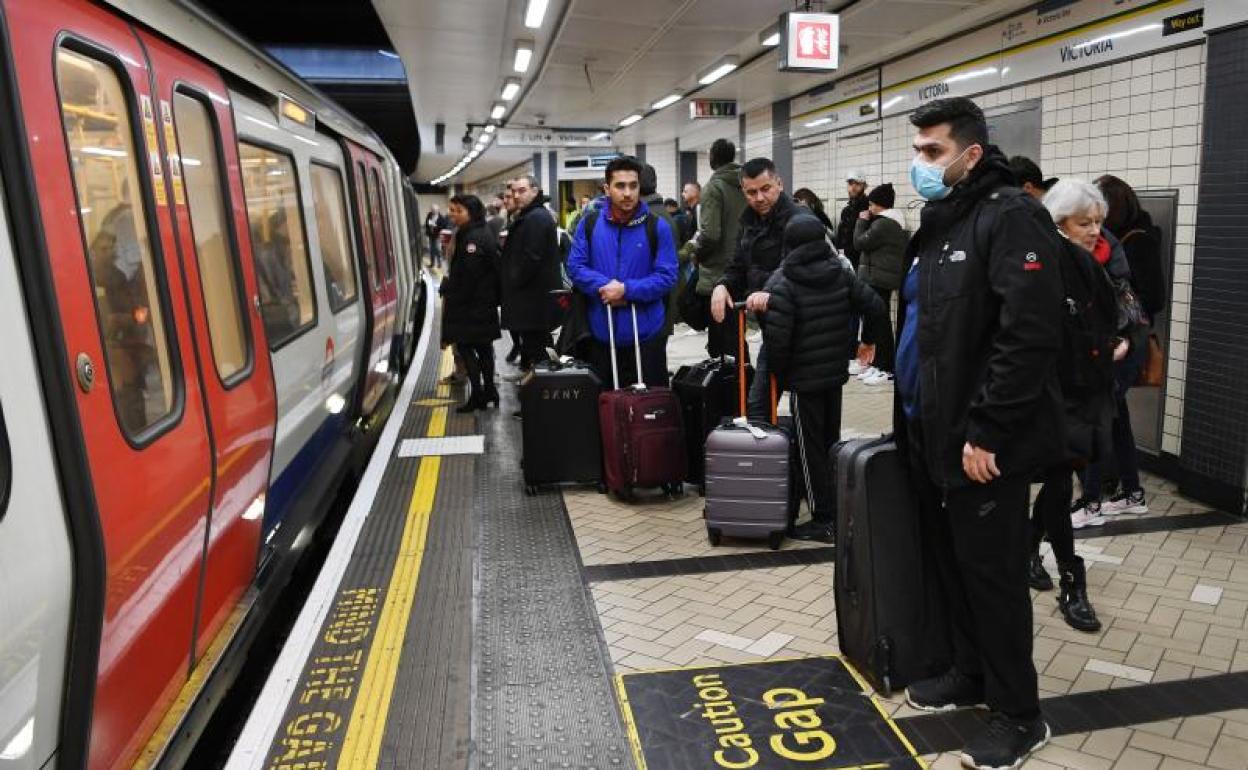 Un hombre, con mascarillas, en el metro de Londres.