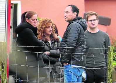 Imagen secundaria 1 - Una veintena de submarinistas de distintos cuerpos de emergencia trabajaron para encontrar el vehículo en el Urumea. | Familiares y conocidos de los accidentados aguardan frente a un caserío los resultados del rescate. | Una grúa logró extraer el coche del río pasadas las 21.00 horas.