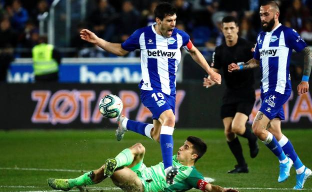 Manu salta para evitar la entrada de Bustinza. 