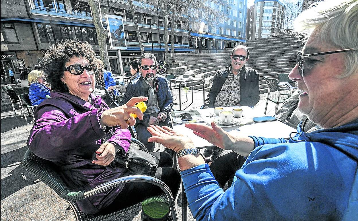 Iosune y Rosi se aplican gel antibacteriano en una terraza de la plaza de Los Fueros. 