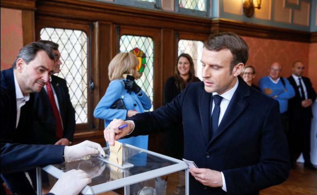 El presidente francés, Emmanuel Macron, deposita su voto en un colegio electoral de París.