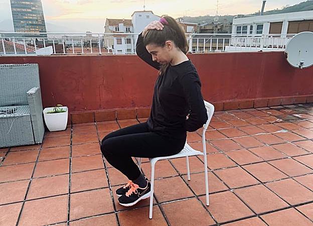 Una modelo realiza un estiramiento del elevador de la escápula. 