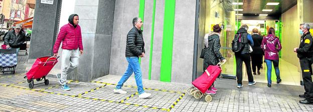 Varios clientes entran en un 'super' manteniendo la distancia de seguridad.