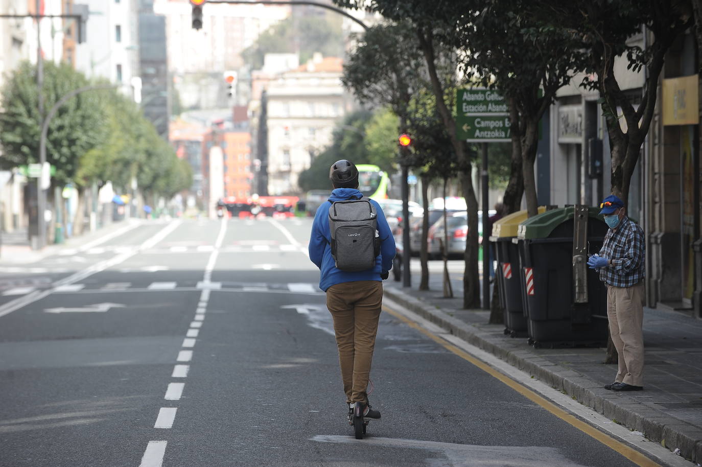 Un joven con un patinete eléctrico en la calle Hurtado de Amezaga vacía.