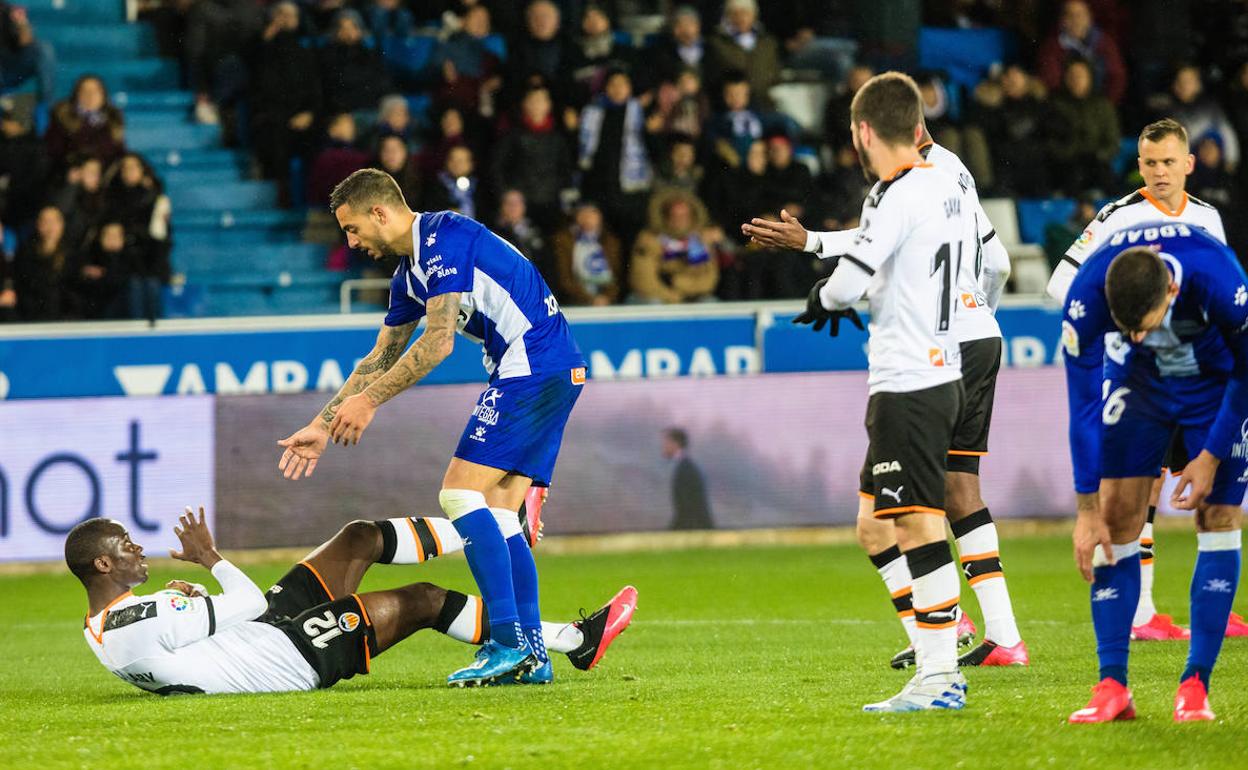 Joselu ayuda a levantarse a un rival en el Alavés-Valencia del pasado 6 de marzo. 