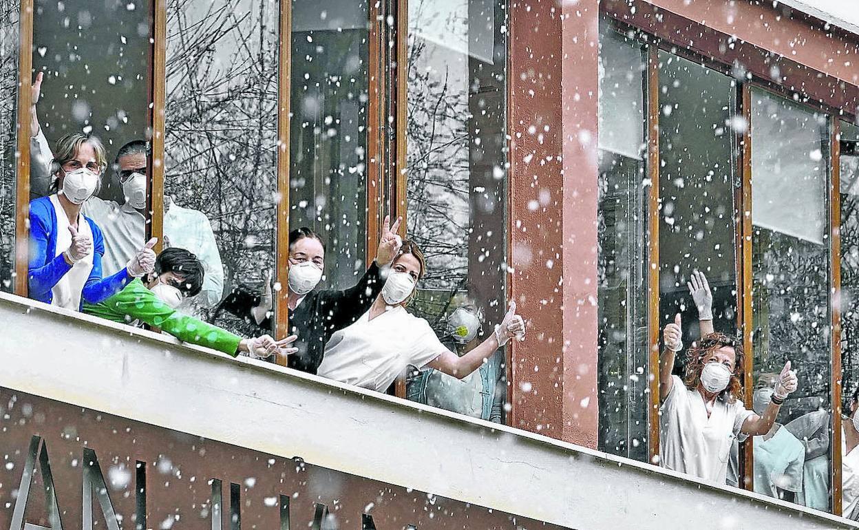 Personal de la residencia San Juan de Zestoa, una fundación sin ánimo de lucro, saluda desde las ventanas en mitad de la nevada que cayó en la localidad guipuzcoana. 