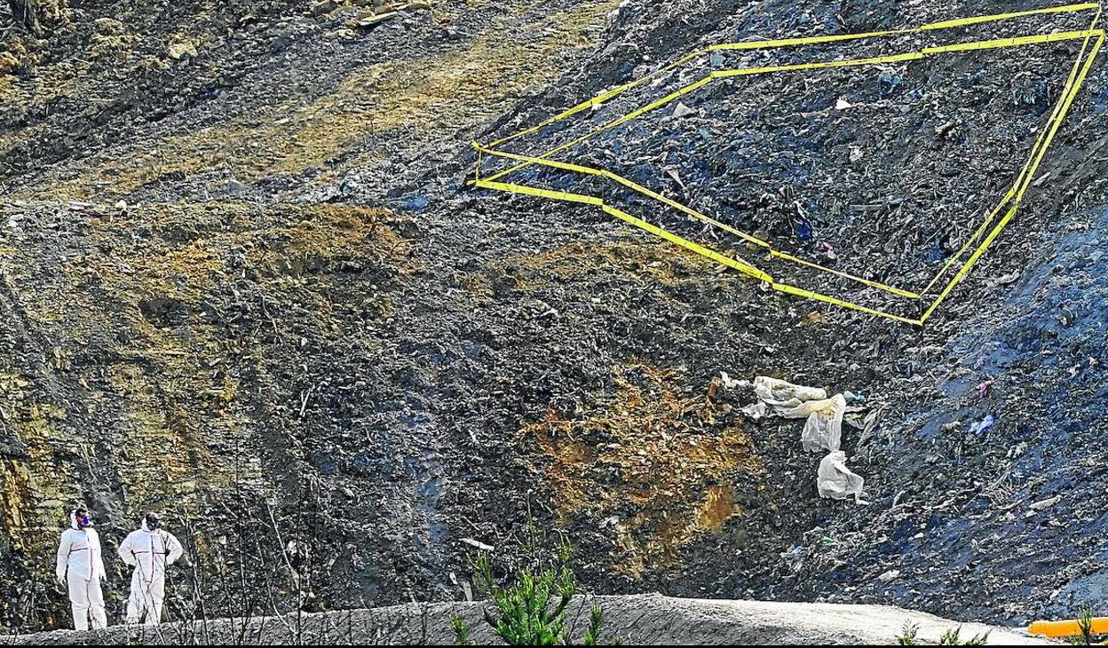 Los operarios trabajan junto a un depósito de restos de uralita aparecido durante la excavación y ahora acordonado.