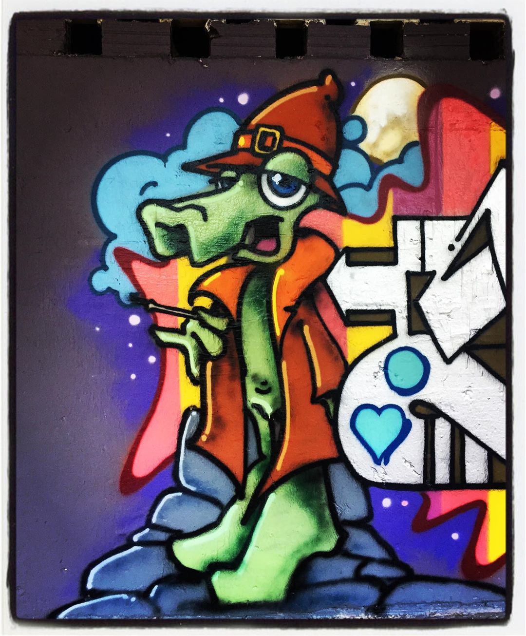 Sombrero, gabardina y cigarrillo. Podría parecer la imagen de un detective a la antigua usanza, pero no. Se trata del modo en que se ha retratado a este colorido, a la par que elegante, cocodrilo.