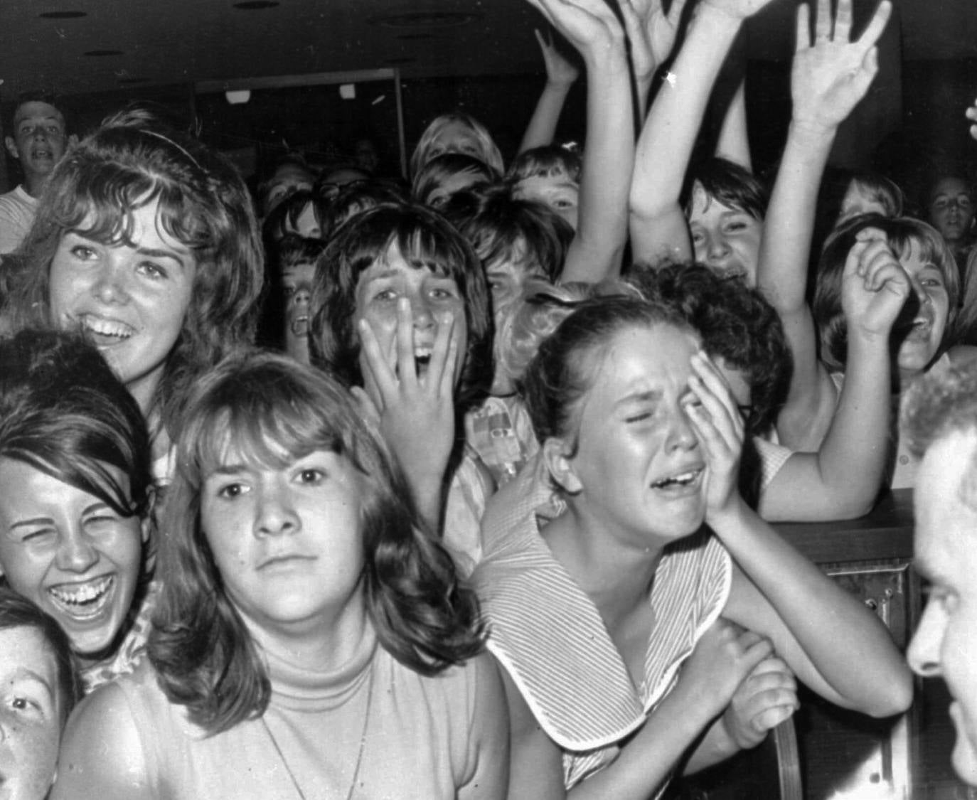 Jóvenes 'fans' de "Los Beatles", histéricas, al ver fugazmente a sus ídolos en el aeropuerto Internacional de Los Ángeles.