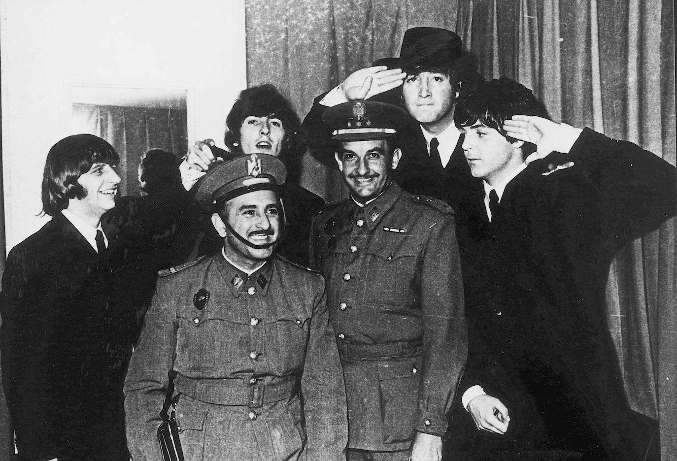 Los Beatles posando junto a un militar y un policía armada españoles durante su visita a España en 1965.