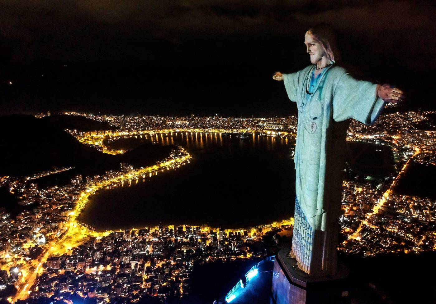 Vista aérea de la estatua del Cristo Redentor con una proyección de trabajadores de la salud, durante un acto religioso para celebrar el domingo de Pascua, en el Monte Corcovado (Brasil).