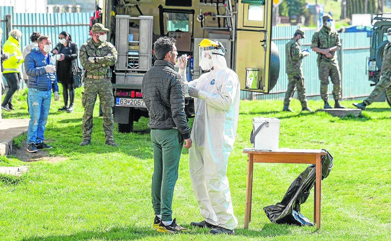 Militares eslovacos realizan pruebas de coronavirus a las afueras del asentamiento Roma, en la localidad de Janovce, en el este del país.